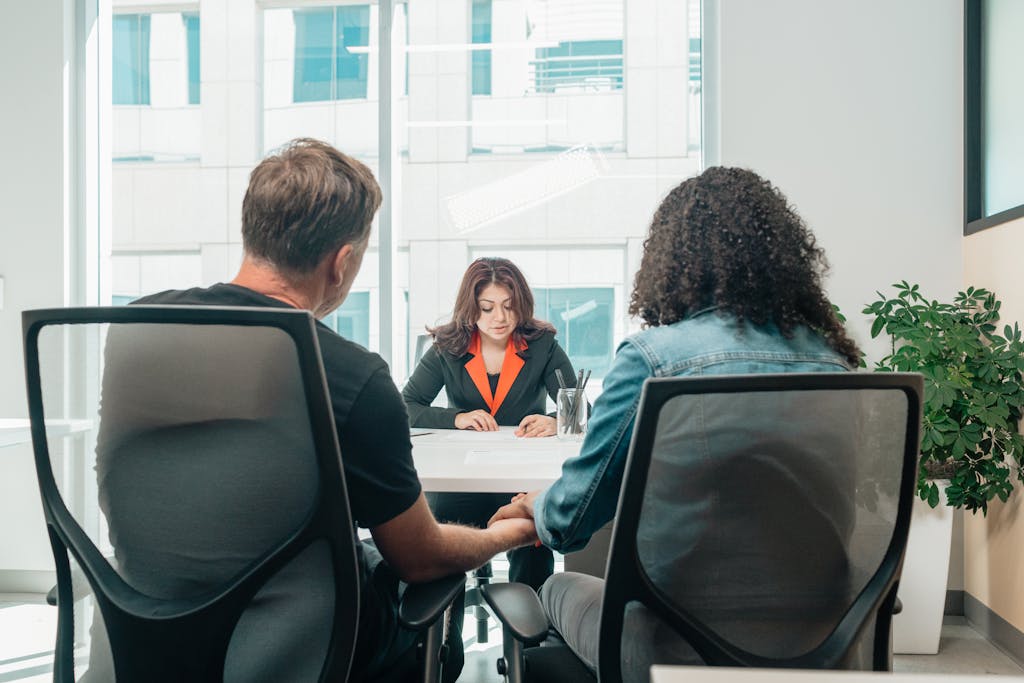 Franchise attorney reviewing a franchise disclosure document with their clients in a formal office setting with legal statue in view.