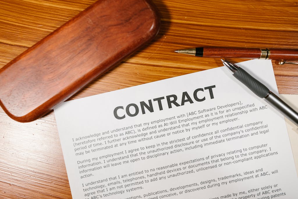 A close-up view of a contract and pen on a wooden desk, ideal for business themes focusing on termination clauses in a contract. 
