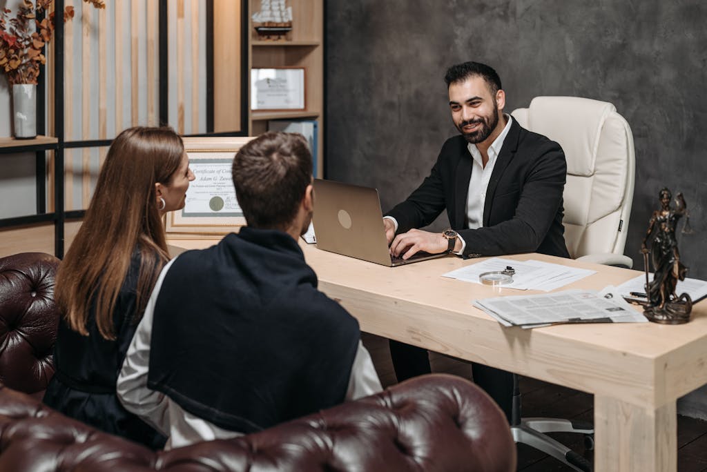 A professional meeting with a lawyer consulting clients on asset protection strategies in an upscale office environment.