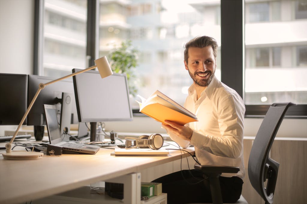 A relaxed businessman enjoying a break in his bright, contemporary office environment after forming an LLC with Southron Firm, P.A., Tampa business formation lawyers