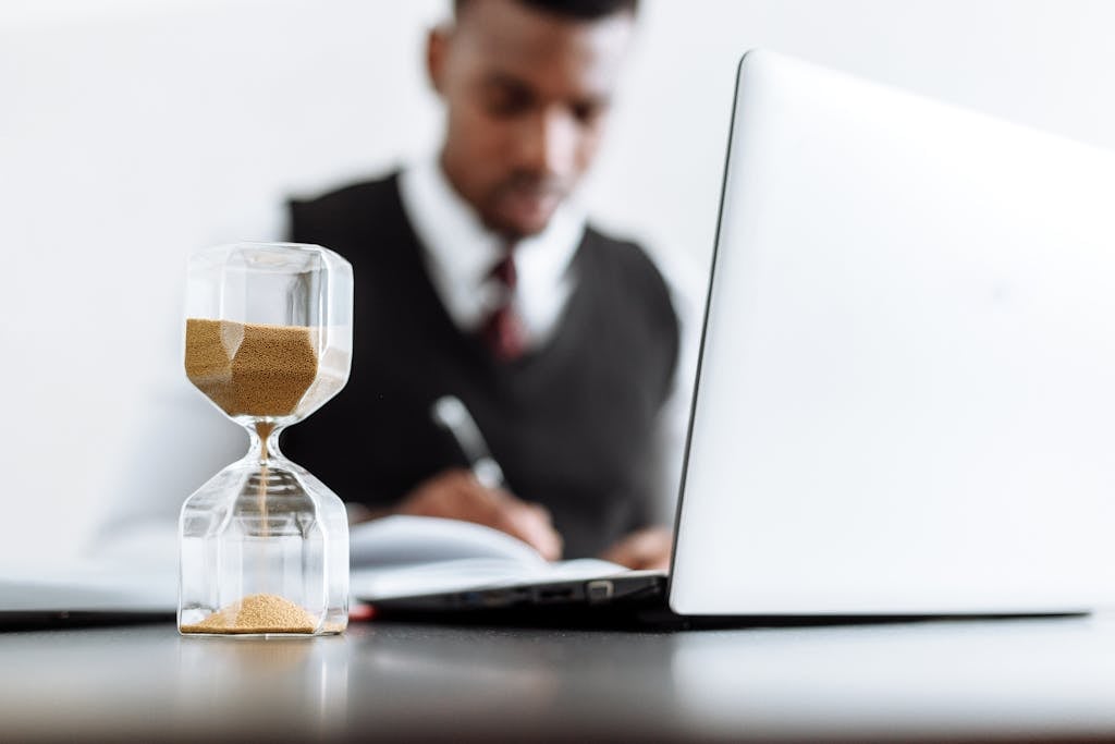 Businessman at desk with hourglass indicating time management and daily work routine reviewing a non-solicitation agreement.