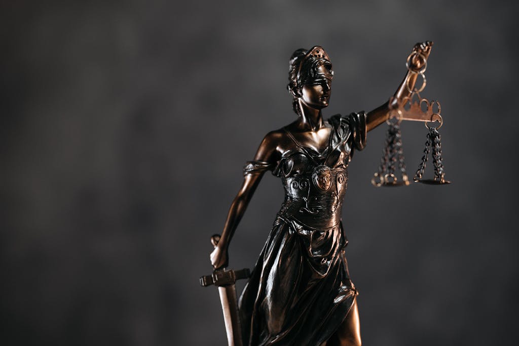 Detailed bronze Lady Justice statue with scales and sword against a dark background, symbolizing law and justice for a durable power of attorney case.