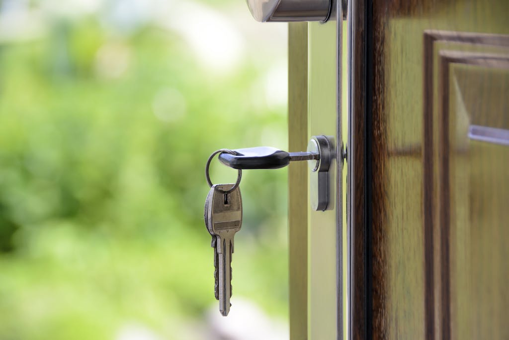 Key inserted in door lock against a blurred green background, symbolizing a quiet title action on a property. 