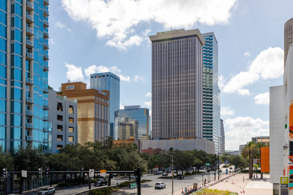 Stunning view of Tampa's skyline featuring modern skyscrapers under a blue sky with clouds. Highlighting the demand for real estate transactions in Tampa's growing business community.