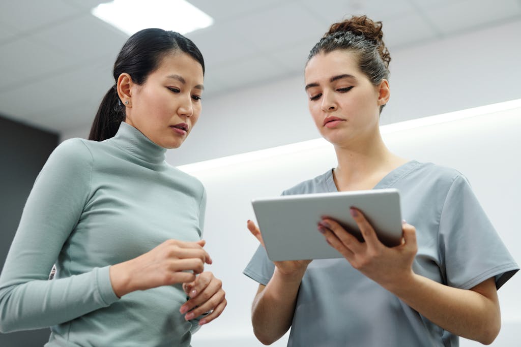 Two women engaged in a healthcare consultation using a digital tablet indoors talking about the importance of establishing advanced directives.
